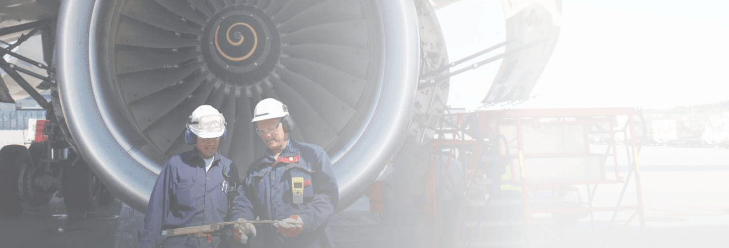 Two mechanics standing in front of a plane